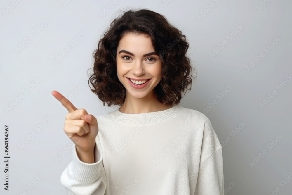 Young woman smiling and pointing with finger Young woman smiling and pointing with finger