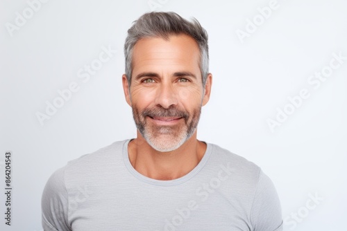 Portrait of a satisfied man in his 40s showing off a thermal merino wool top in front of white background