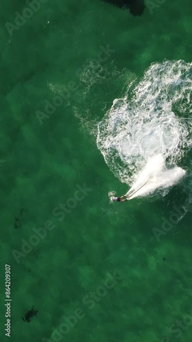 A man flies on a FlyBoard. Aerial top down view. Water extreme sport, azure summer sea with outdoors active people enjoying water sports. Flyboarding and seariding, Recreation and sports concepts. photo