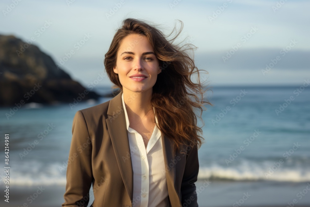 Portrait of a satisfied woman in her 20s dressed in a stylish blazer isolated in tranquil ocean backdrop Portrait of a satisfied woman in her 20s dressed in a stylish blazer isolated in tranquil ocean backdrop