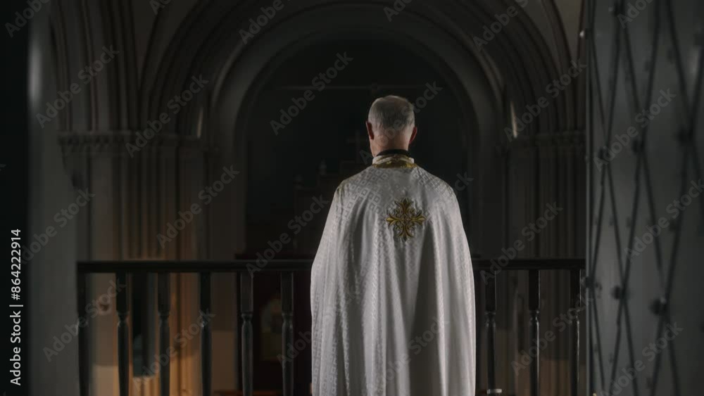 Senior priest in white robe standing on balcony in cathedral, then turning to side with Bible in hands Senior priest in white robe standing on balcony in cathedral, then turning to side with Bible in hands