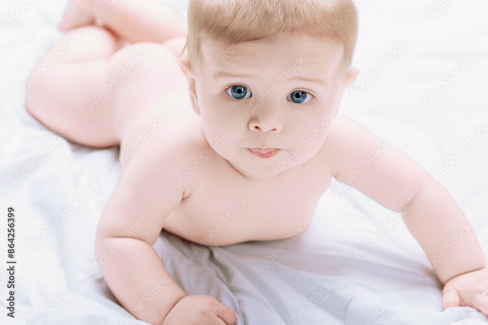 Adorable baby boy lying on stomach on white blanket Adorable baby boy lying on stomach on white blanket