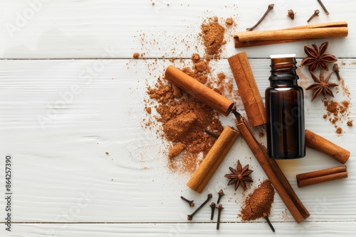 Cinnamon sticks powder and essential oil arranged on a white wooden background creating a vibrant copy space image photo