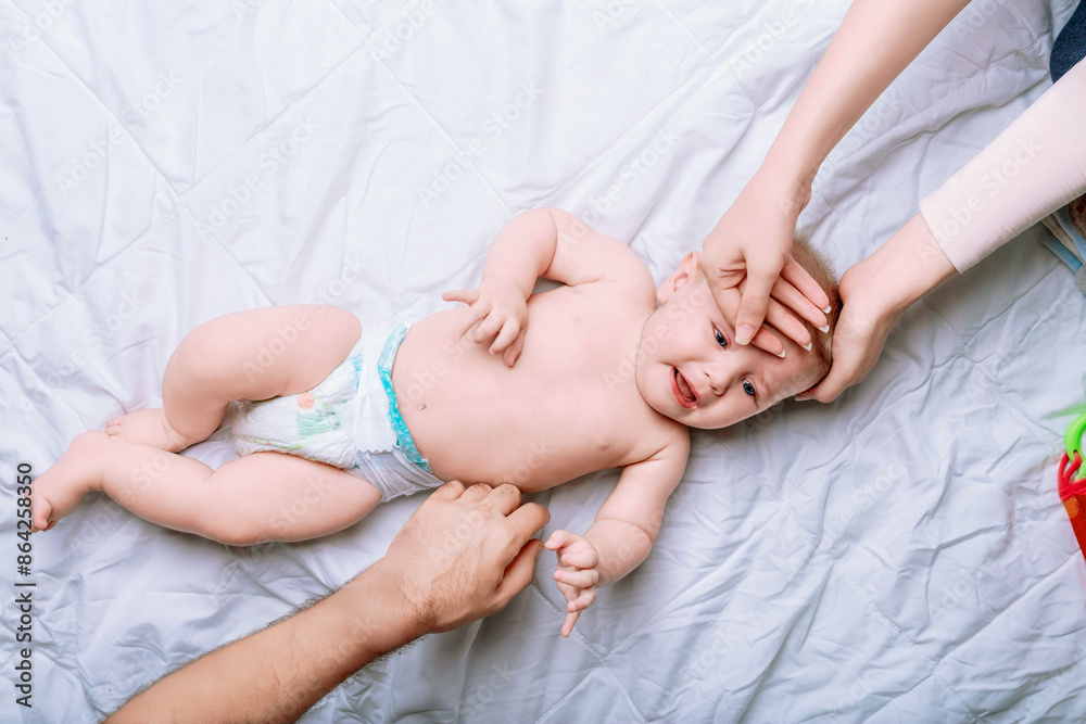 Parents taking care of crying baby lying on back Parents taking care of crying baby lying on back