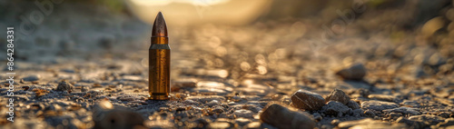 Bullet casing on a dirt road at sunset, close-up view. Military and conflict concept