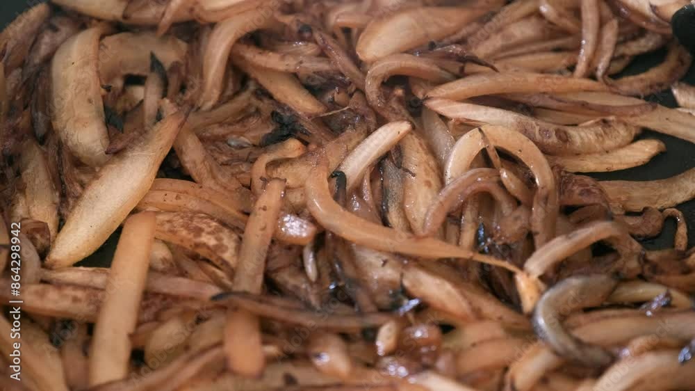 Close up view for onions being fried inside a pan while onions are ready and well done for being used as food toping or in the recipe Close up view for onions being fried inside a pan while onions are ready and well done for being used as food toping or in the recipe