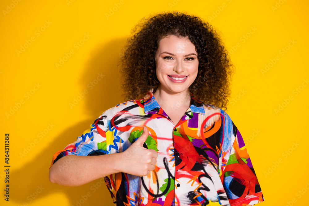 Photo portrait of lovely young lady thumb up dressed stylish colorful print garment isolated on yellow color background Photo portrait of lovely young lady thumb up dressed stylish colorful print garment isolated on yellow color background