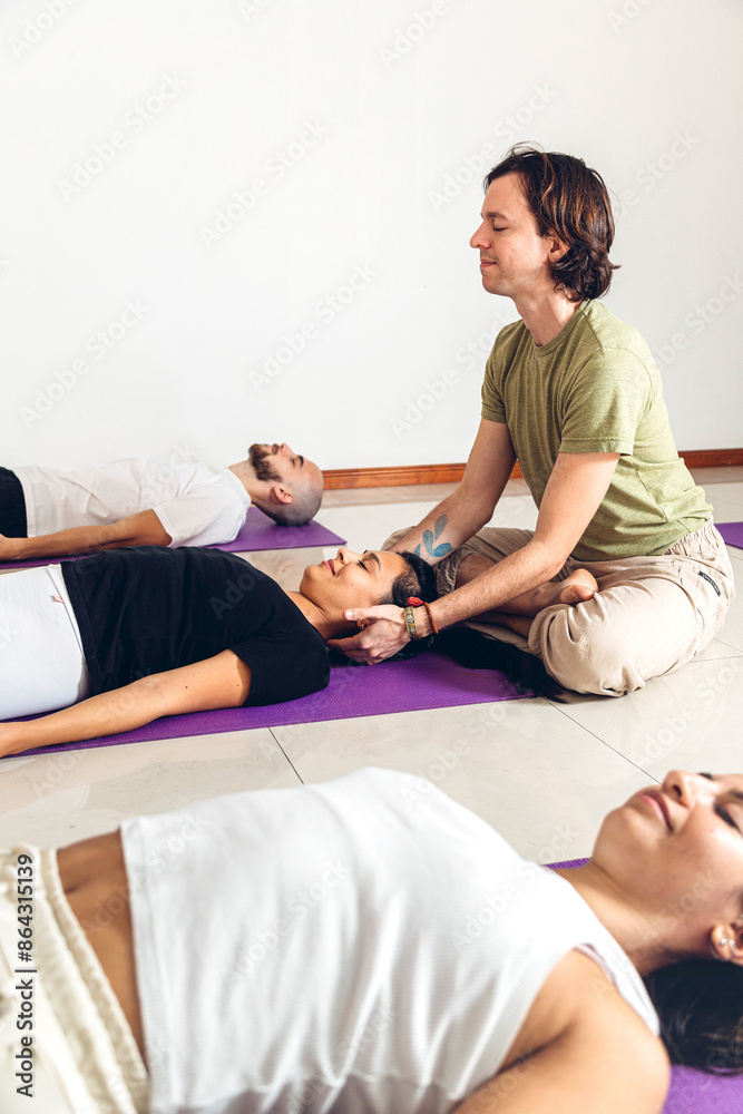 Obraz premium Ayurvedic Yoga Massage. Teacher massaging his students. Vertical composition.