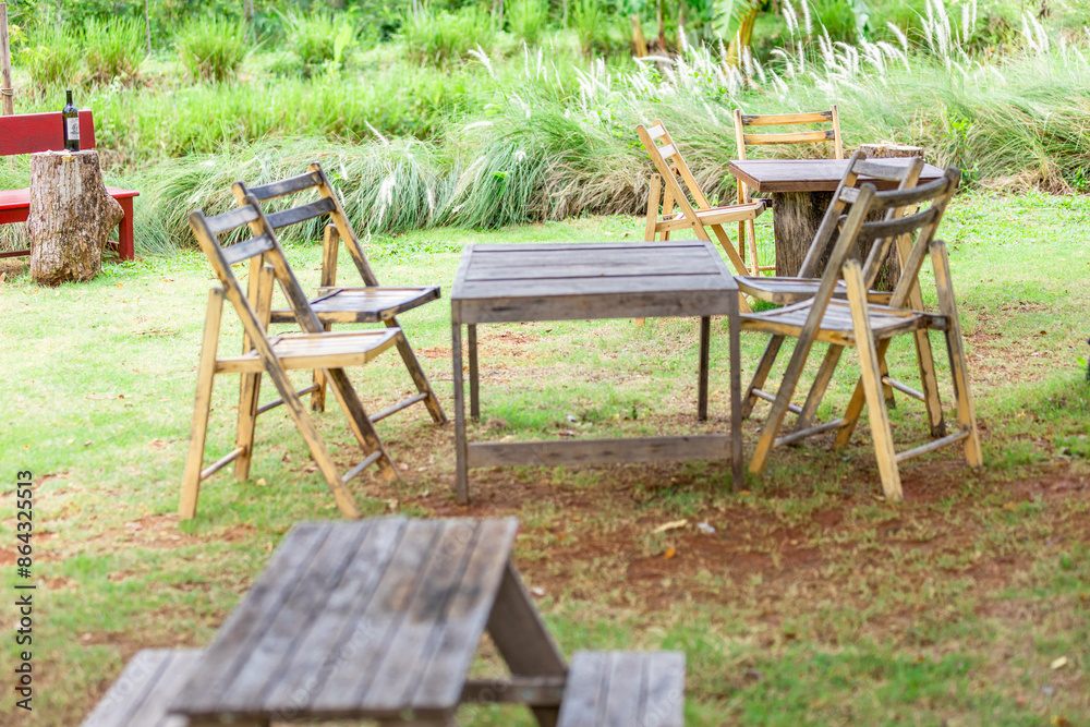 The background of the park decoration has a corner table and wooden chairs for sitting and relaxing during the day. Amidst the various flowers, the beauty of the green grass.