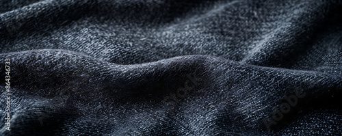 Close-up of a dark gray soft textile material, highlighting the texture and weave of the fabric