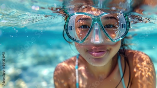 A young girl smiling underwater and wearing a swim mask, enjoying the pristine clear waters, encapsulating the joy of adventure and exploration in a serene aquatic environment.