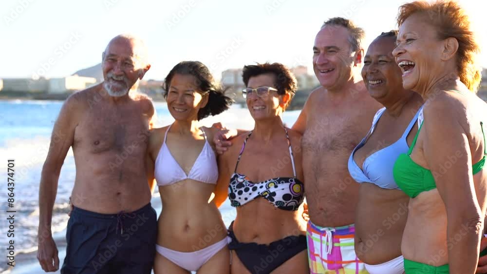 Group of senior friends hugging each other on the beach - Joyful elderly people enjoy travel vacation together Group of senior friends hugging each other on the beach - Joyful elderly people enjoy travel vacation together