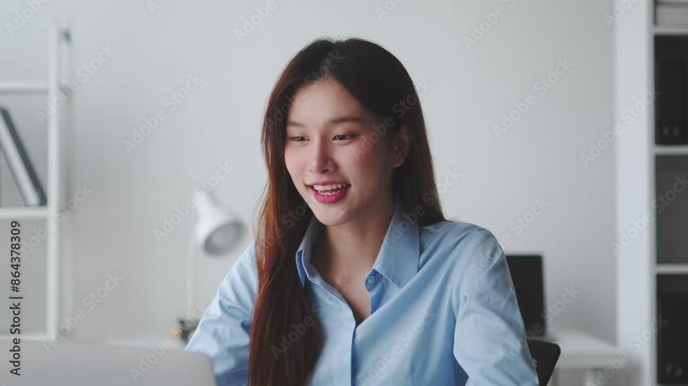 Young professional woman engages in a lively online call at her office desk, smiling, laughing, and gesturing expressively Young professional woman engages in a lively online call at her office desk, smiling, laughing, and gesturing expressively