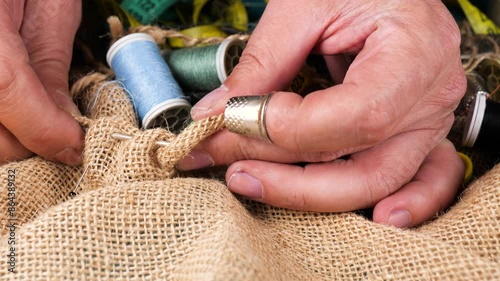 Tailor man is sewing. Close-up of a hand holding a needle. 4k video capture