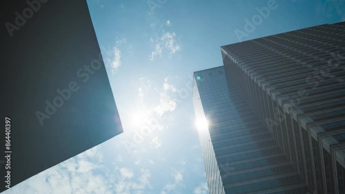 Time lapse photography between buildings in Seoul. Clouds pass through buildings and the sun shines through the clouds.