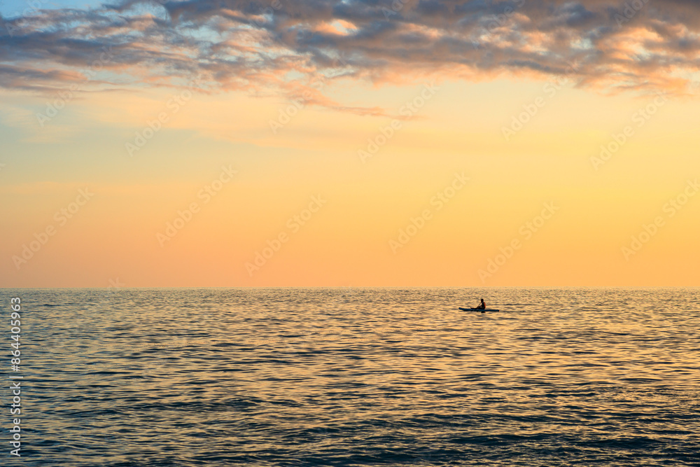A man is swimming in the ocean at sunset A man is swimming in the ocean at sunset