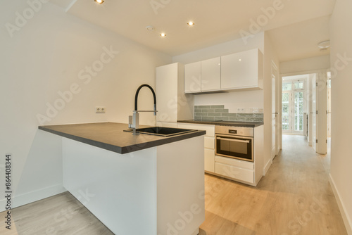 A kitchen with white cabinets and a black counter top