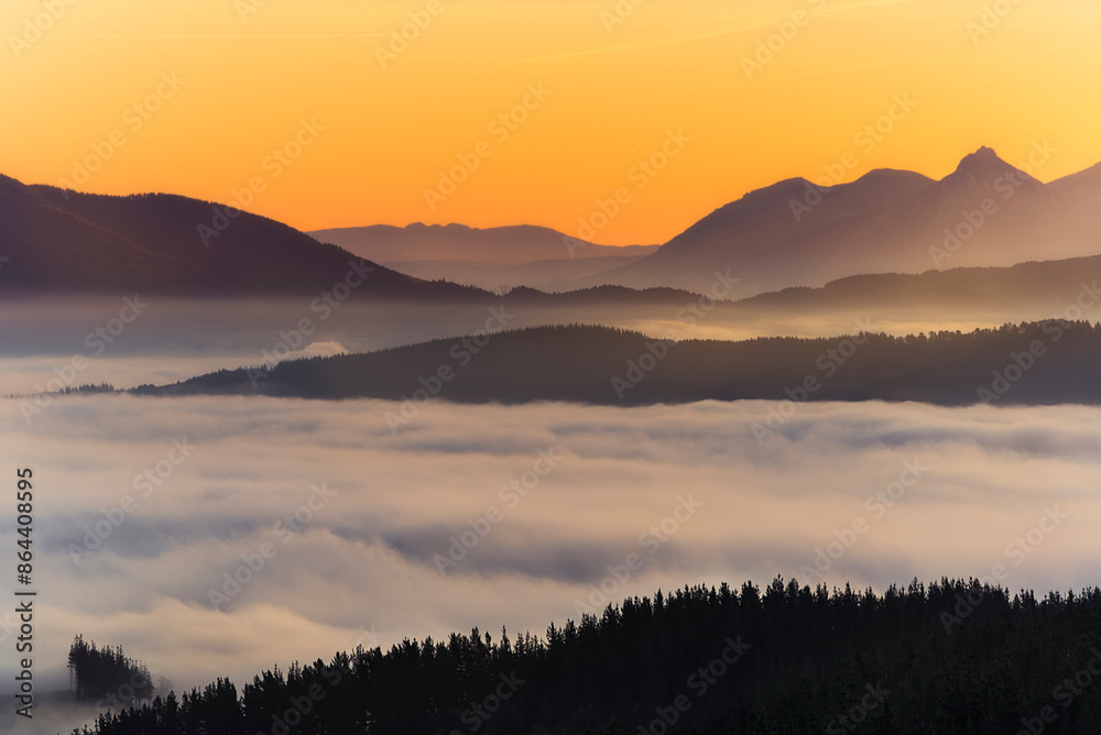 Warm sunrise over the Aramaio Valley, Araba, covered by a sea of low clouds Warm sunrise over the Aramaio Valley, Araba, covered by a sea of low clouds