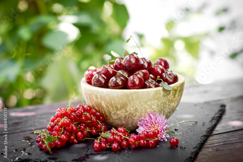 Cherries in bowl, fresh organic cherry and red currant on table