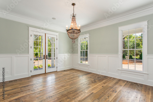 Фотография Bright Dining Room with Double Doors, Chandelier, and Natural Light Coming In