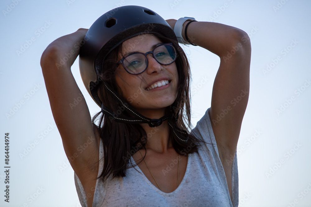 Naklejka premium Female Skateboarder wearing helmet looking towards camera - horizontal