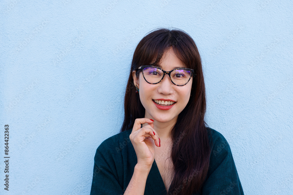 Happy Asian Woman Smiling With Eyes Closed And Glasses Over Light Blue Background Happy Asian Woman Smiling With Eyes Closed And Glasses Over Light Blue Background