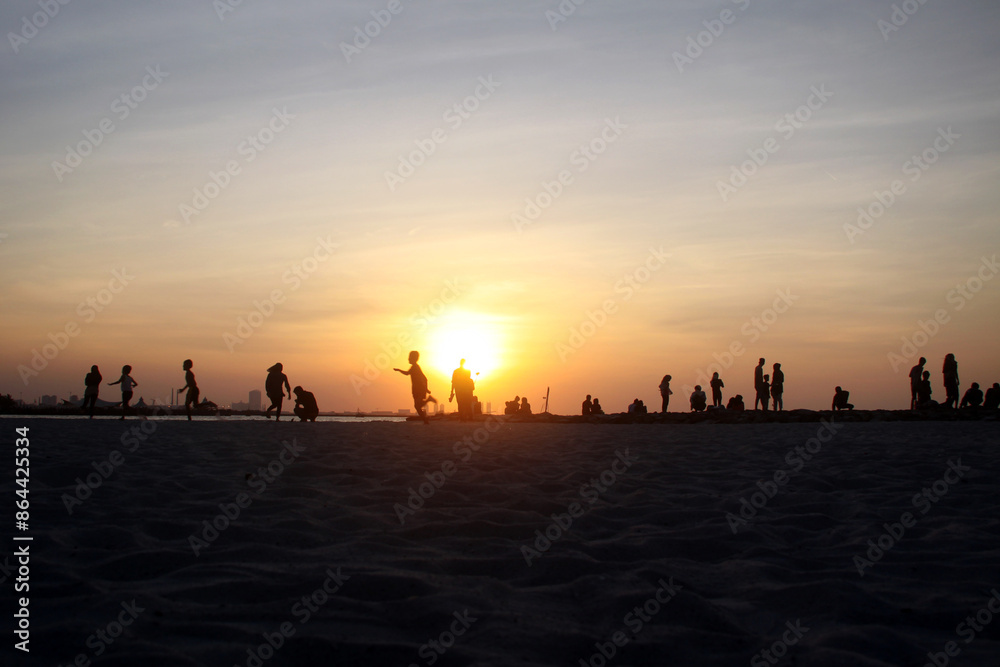 Sunset on the beach, Silhouettes of People on the Beach at Sunset