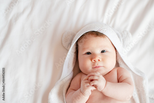 Fotografia Portrait of a sweet little newborn baby girl after a bath in a white hooded towel
