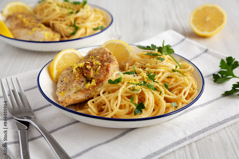 Homemade Lemon Pepper Chicken with Spaghetti Pasta on a Plate, side view. Homemade Lemon Pepper Chicken with Spaghetti Pasta on a Plate, side view.