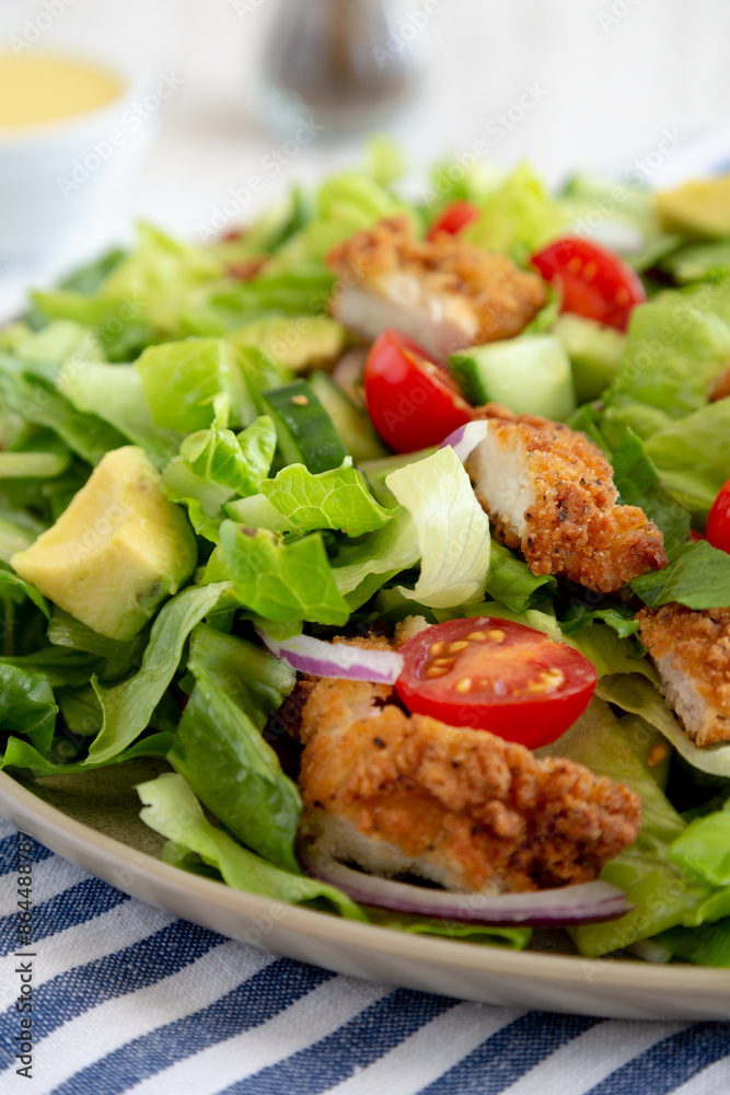 Homemade Crispy Chicken Salad with Tomato and Cucumber on a Plate, side view. Close-up. Homemade Crispy Chicken Salad with Tomato and Cucumber on a Plate, side view. Close-up.
