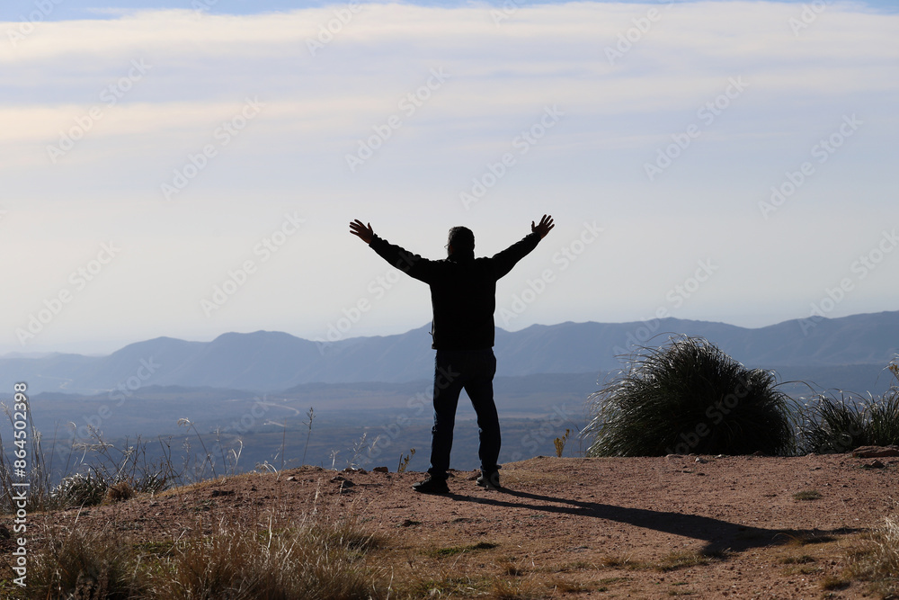Silhouette of a man with his arms open and extended as a sign of freedom with a mountainous landscape in the background. Concept of freedom, happiness, achievements, successes, liberation, outdoor
Silhouette of a man with his arms open and extended as a sign of freedom with a mountainous landscape in the background. Concept of freedom, happiness, achievements, successes, liberation, outdoor