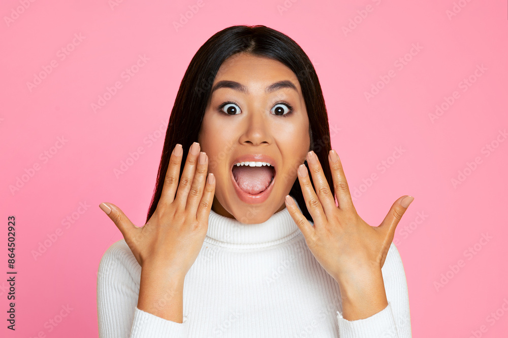 Asian woman with long, dark hair wearing a white turtleneck sweater. She is looking at the camera with a surprised expression, her eyes wide and her mouth open in a gasp Asian woman with long, dark hair wearing a white turtleneck sweater. She is looking at the camera with a surprised expression, her eyes wide and her mouth open in a gasp