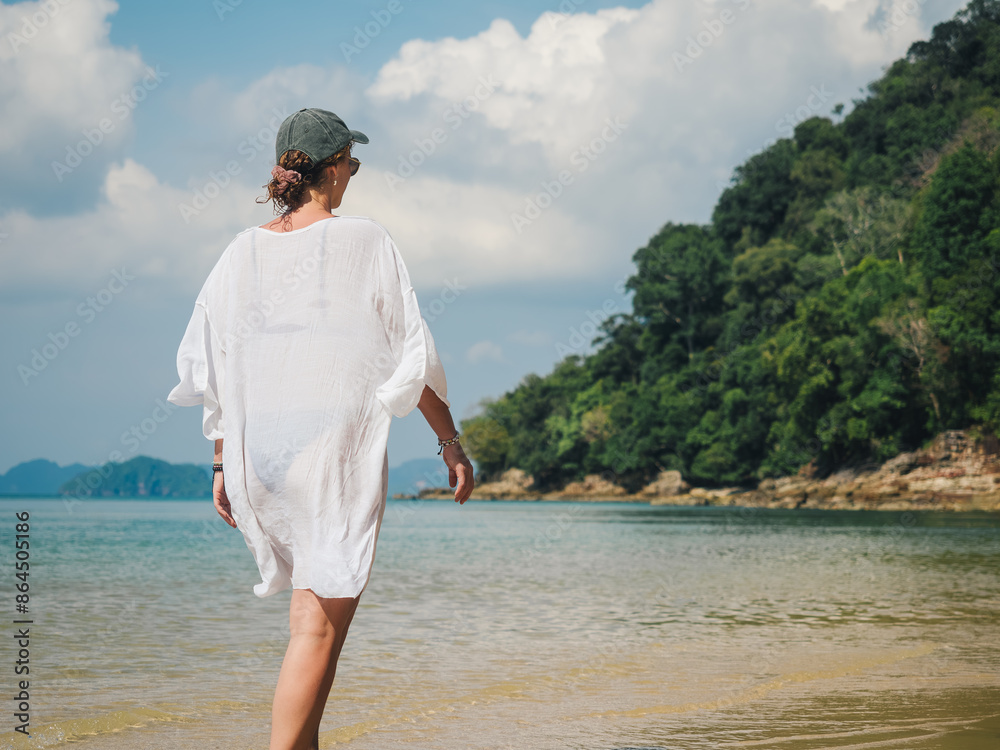 Young Woman Walking on a Serene Tropical Beach on Holidays - Relaxation Concept Young Woman Walking on a Serene Tropical Beach on Holidays - Relaxation Concept