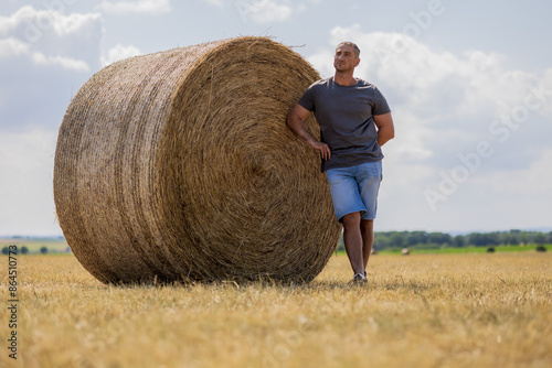 A man leaning on hay Bale in agriculture field  photo