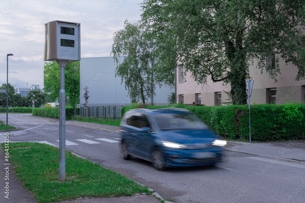 Traffic radar or speed trap in Ljubljana, Slovenia in evening hours. Cars in blur moving past the speed trap, green environment in urban area
