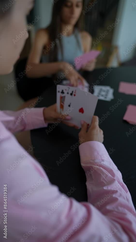 An entertaining card game is in progress among friends in a comfortable home environment An entertaining card game is in progress among friends in a comfortable home environment