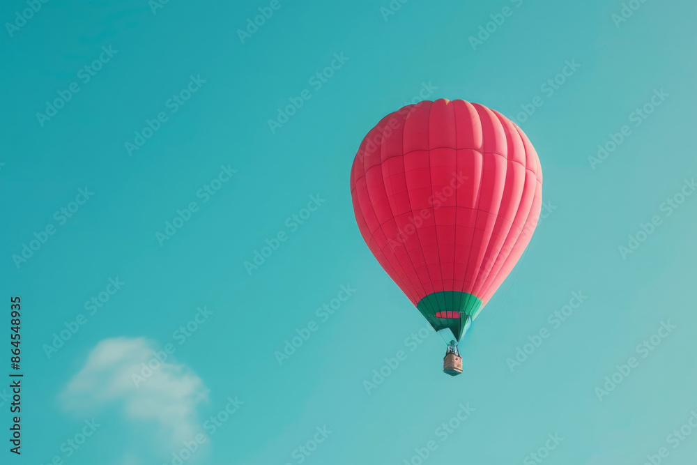 Naklejka premium Red hot air balloon flying in clear blue sky. Adventure and freedom concept