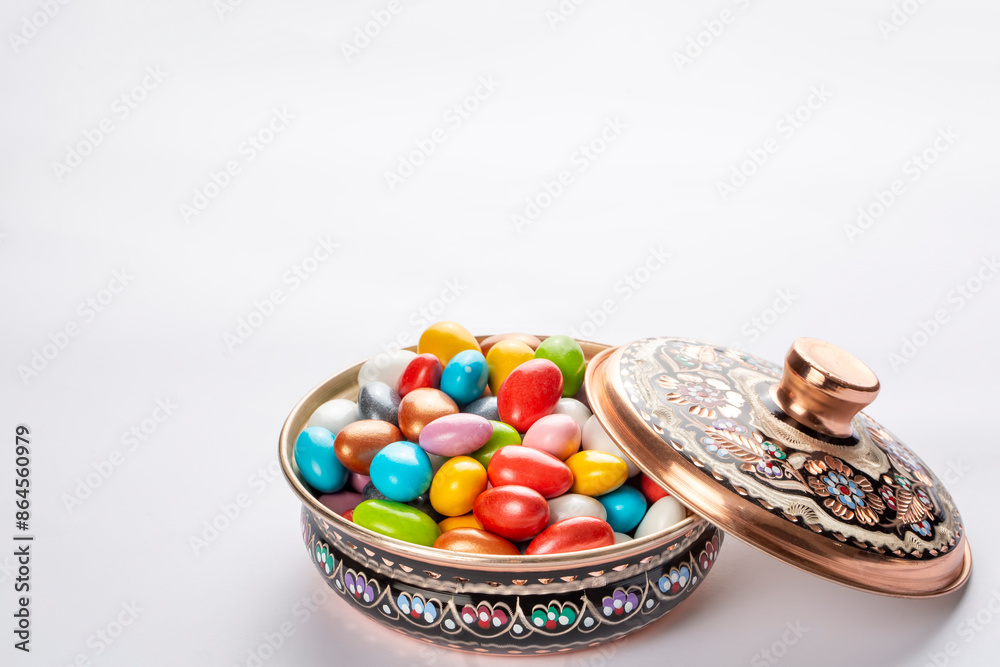 Colorful almond candies in the stylish,crystal candy bowl on white with copy space.The Sugar Feast concept. (Turkish name; Ramadan - Ramazan bayrami, Seker bayrami)