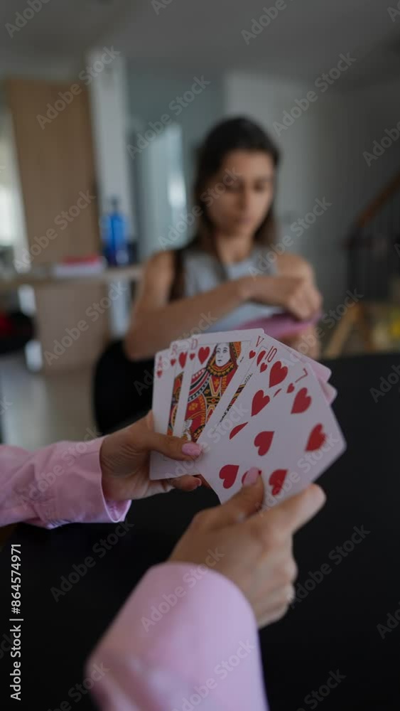 Relishing a peaceful game evening with loved ones, playing cards together in the comfort of home Relishing a peaceful game evening with loved ones, playing cards together in the comfort of home