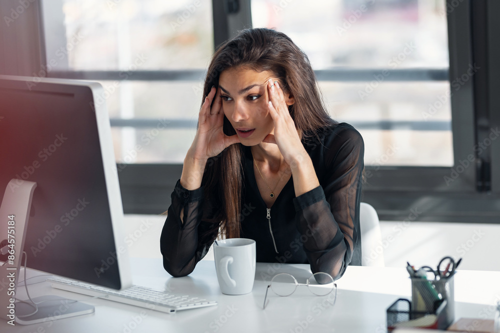 Exhausted elegant business woman with headache while working with computer in the office. Exhausted elegant business woman with headache while working with computer in the office.