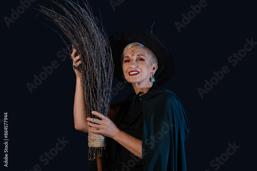 Mature witch with broom on ...