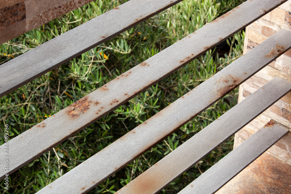 Rusty railing on a balcony against a backdrop of trees. Humidity corrodes the jelly. Horizontal background