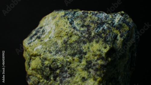 Serpentine close-up shot, green mineral, mottled appearance. Unique patterns and textures of the serpentine surface. Use in decorative stones and architectural applications
