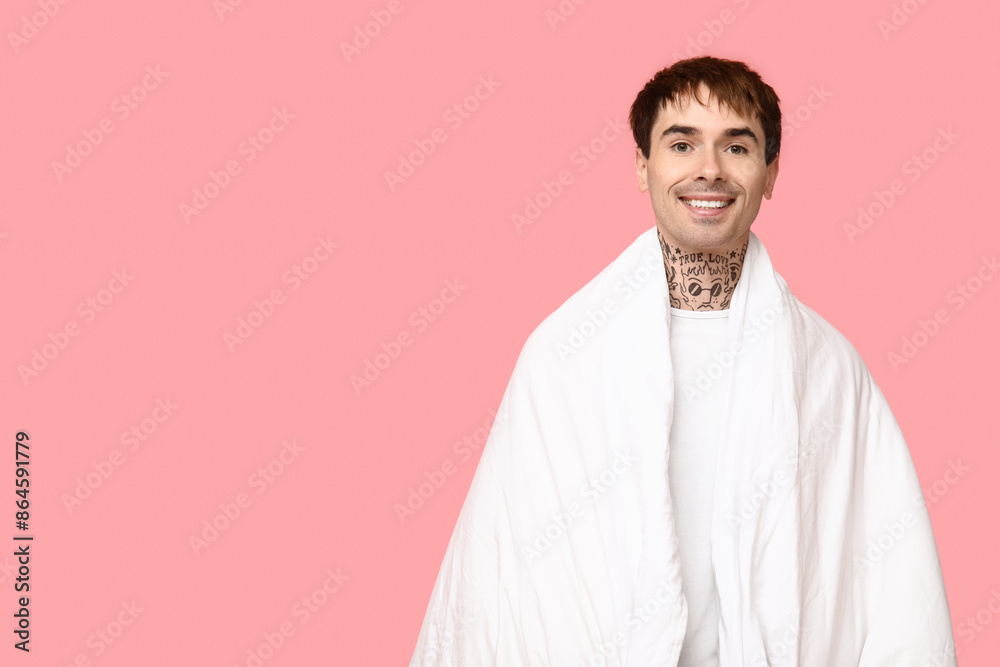 Tattooed young man in pajamas on pink background Tattooed young man in pajamas on pink background