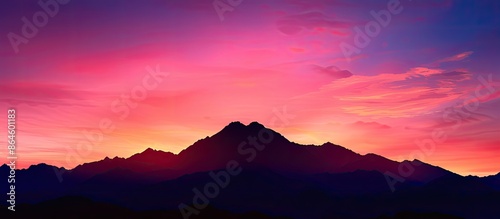 Silhouetted mountain against a vivid sunset, ideal as a backdrop with copy space image.