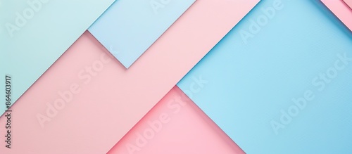 Pastel blue and light pink geometric shapes and lines compliment the abstract colored paper texture background in this image with copy space.