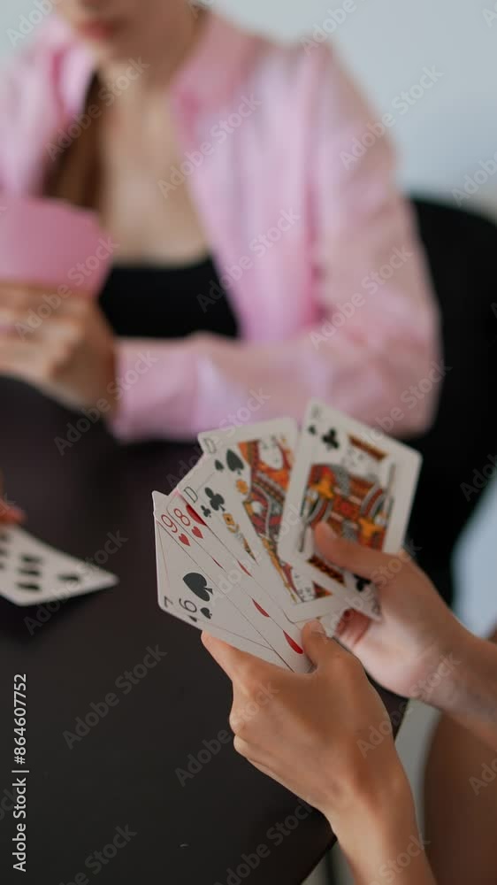 Group of women having a fun time playing cards together indoors in a relaxed setting Group of women having a fun time playing cards together indoors in a relaxed setting