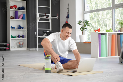 Sporty young man using lapt...