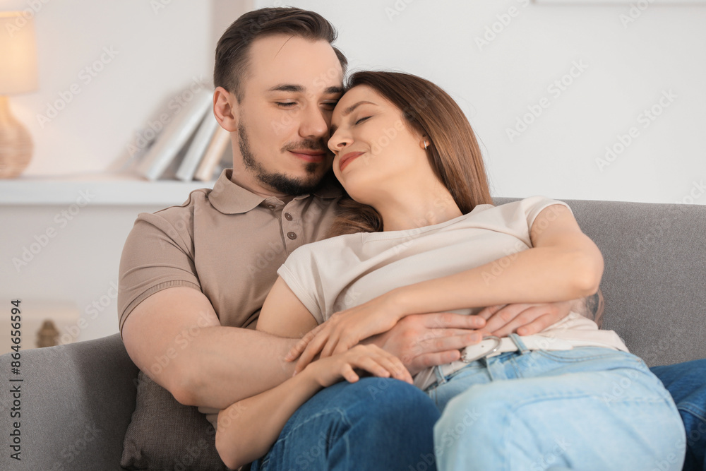 Cute couple hugging on sofa at home Cute couple hugging on sofa at home