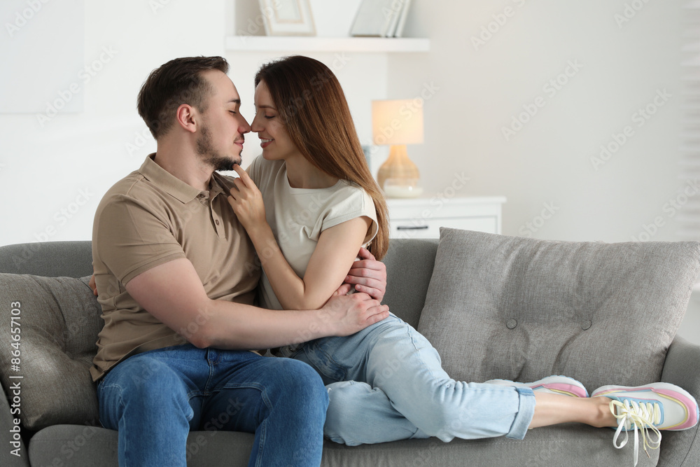 Man hugging his happy girlfriend on sofa at home Man hugging his happy girlfriend on sofa at home